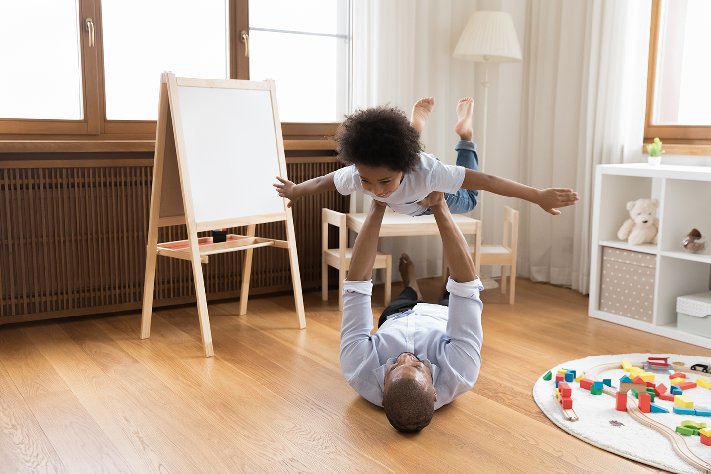 A father is playing with his son indoor.